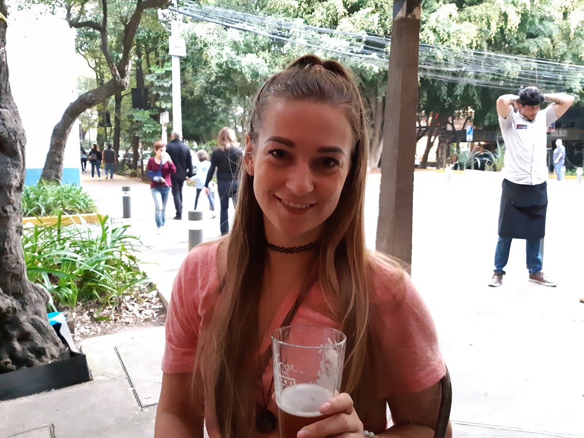 woman drinking a craft beer at an outdoor patio in Mexico City