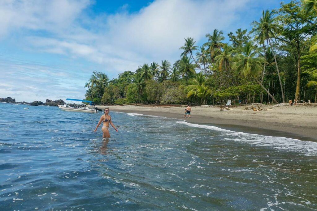 A lady plays in the water at Playa San Josecito after hiking the Drake Trail