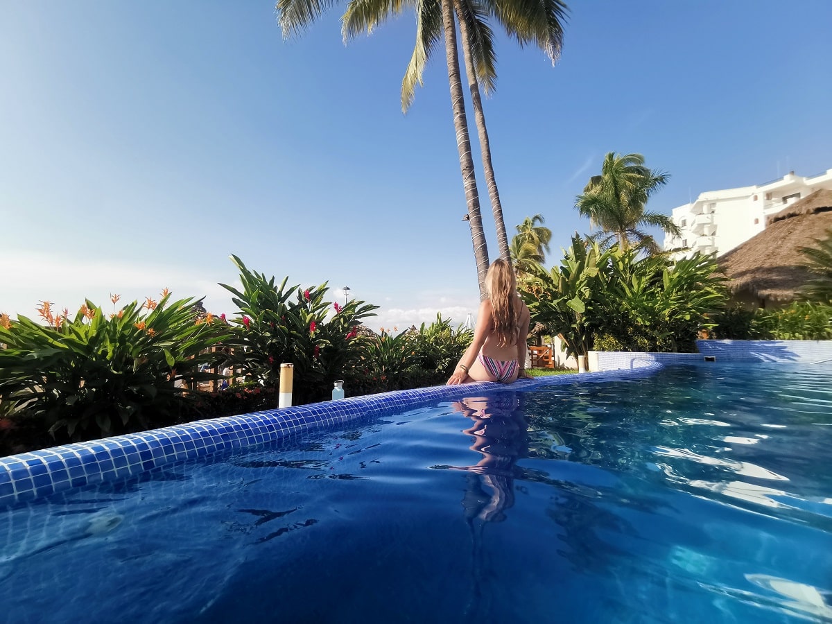 woman sitting on the edge of a hotel pool in Puerto Vallarta