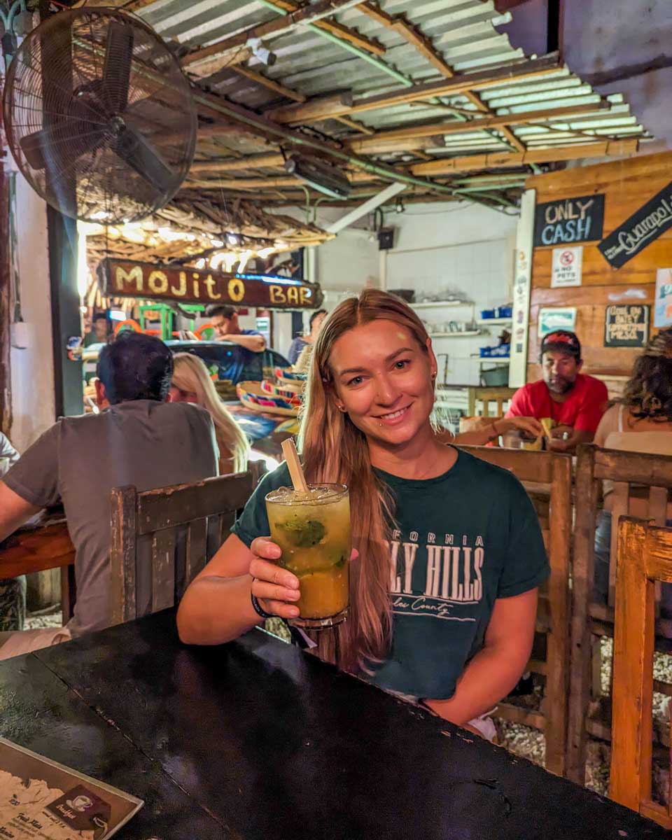 Bailey drinks a mojito at Batey Mojito and Guarapo Bar in Tulum, Mexico