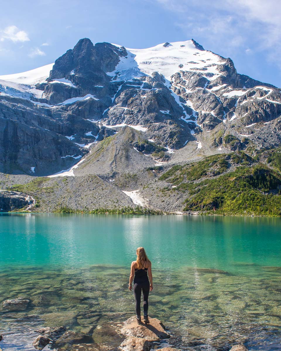 A lady stands on a rock at Upper Joffre Lake