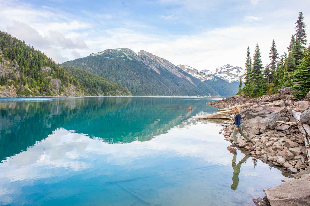 A lady walks along the edge of a lake near Whistler, BC