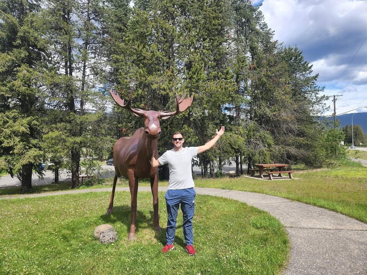 Daniel standing with the iconic moose in Clearwater, BC