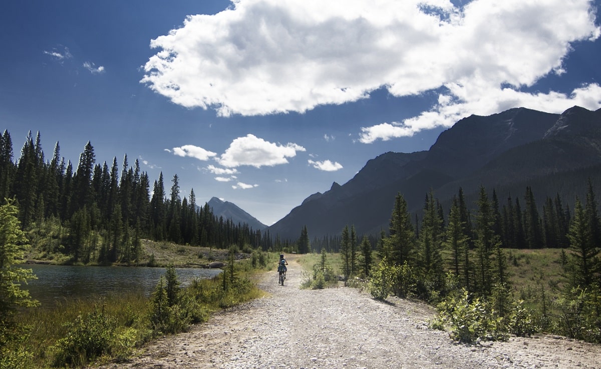 person bicycling in the distance on a trail in Banff National Park