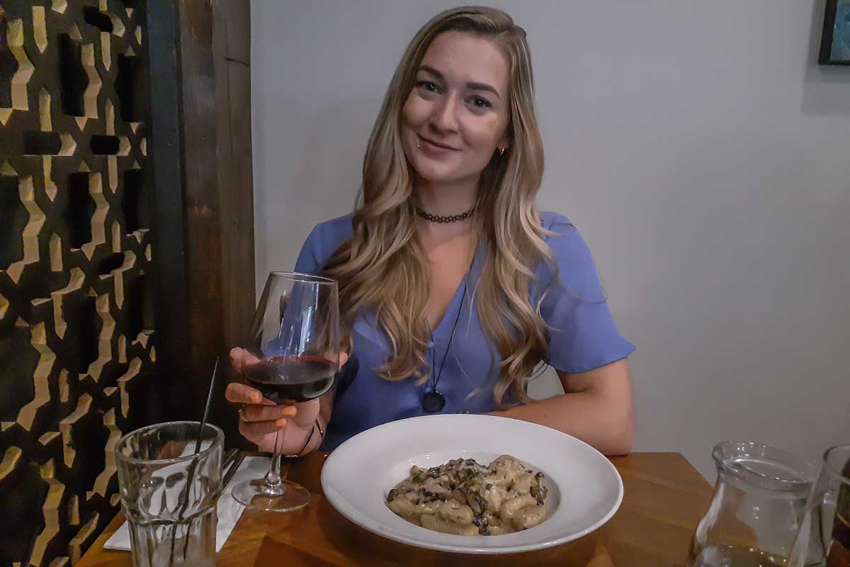 Bailey at Vaticano Cucina, Edmonton with a glass of wine and pasta