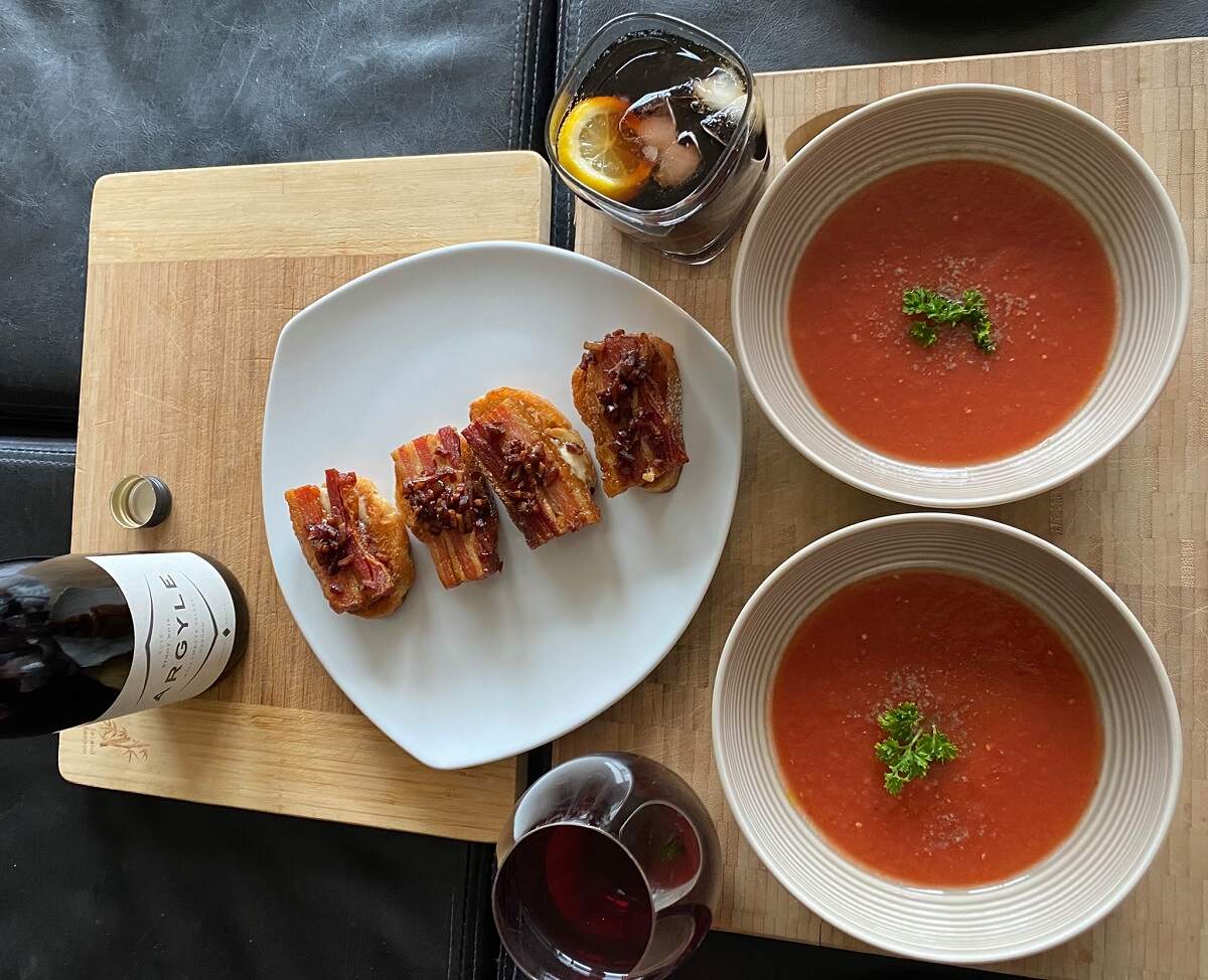 two soups and apetizers on a board with wine at Tzin Wine & Tapas