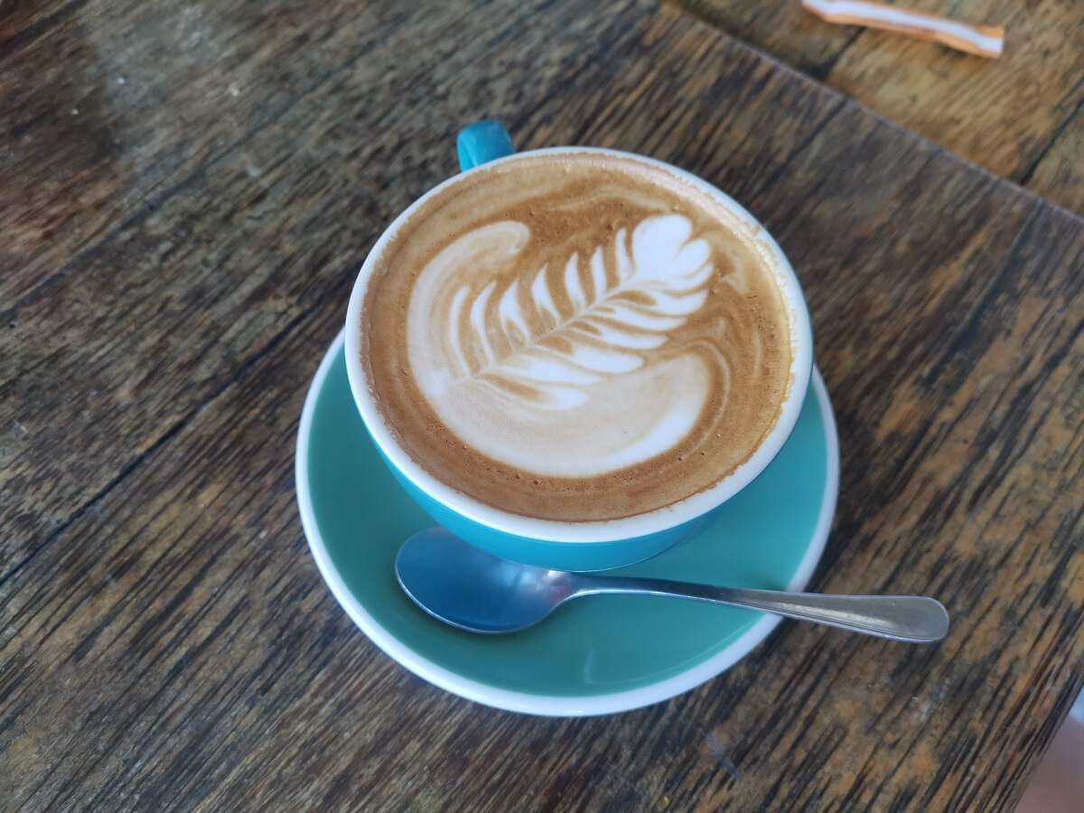 a beautiful blue cup with a coffee and flower latte
