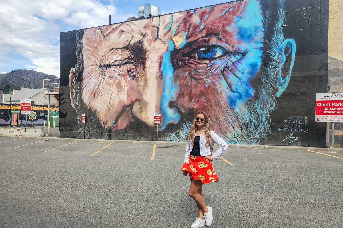 Bailey poses for a photo in front of a huge mural in Kamloops, BC