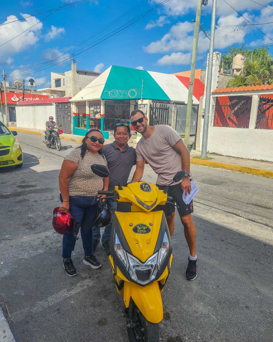 Daniel poses for a photo with his rental scooter and rental company owners on Cozumel, Mexico