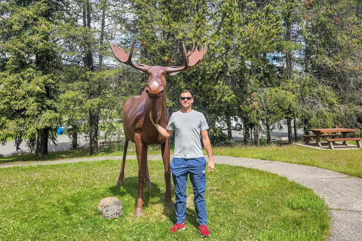 Daniel poses for a photo with the moose statue in Clearwater, BC