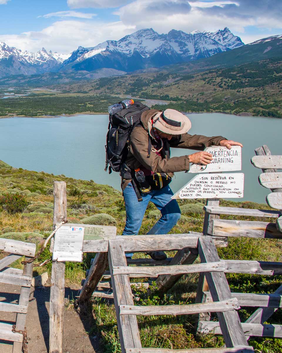 A hiker climbs a fence in Torres del Paine NP