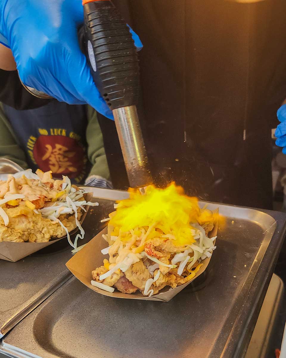A man grills the cheese on our chicken taco at the Richmond Night Market, Vancouver