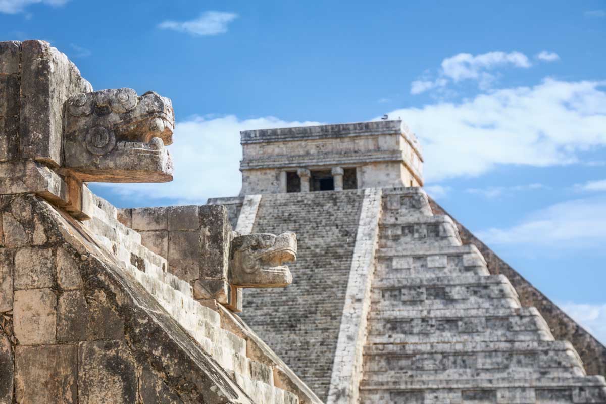 A temple with El Castillo Pyramid in the background at Chichen Itza, Mexico