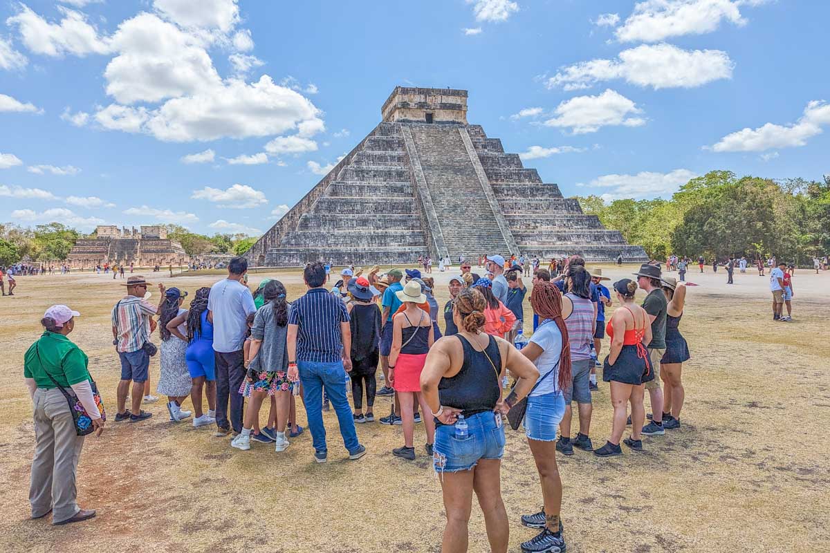 A tour group learns about Chichen Itza at the site