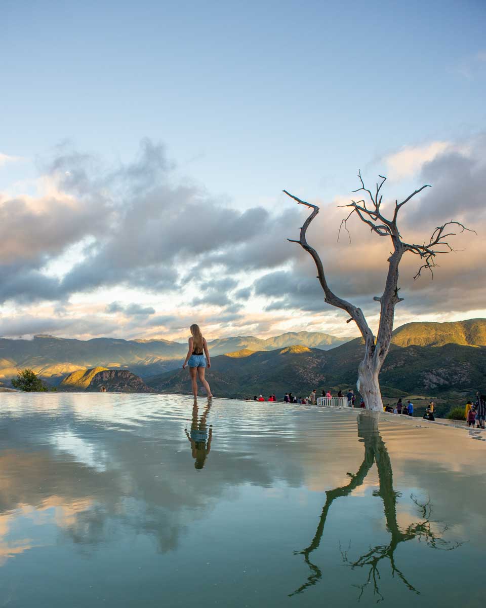 Bailey walks along the edge of a pool at sunset at Hierve El Agua , Mexico