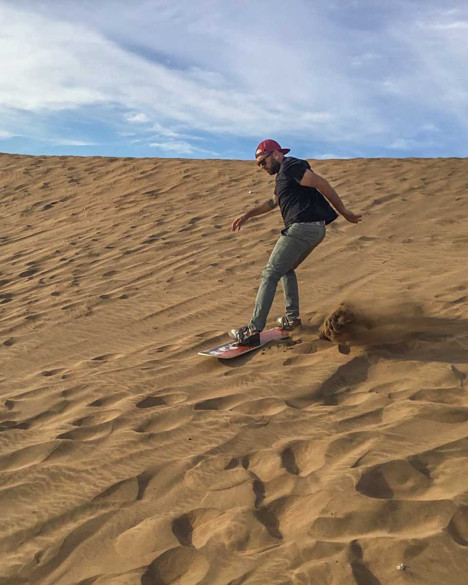 A man sandboards in Valparaiso, Chile with Go Penguins