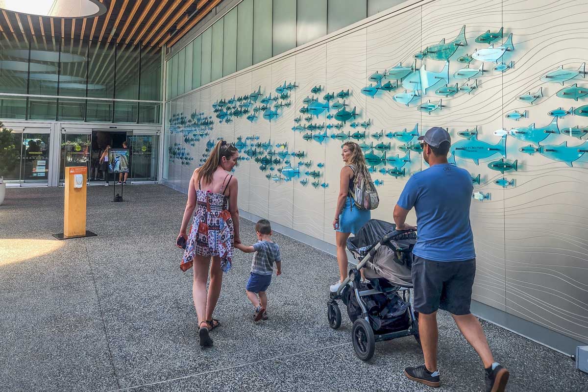 A family push a stroller through the Vancouver Aquarium
