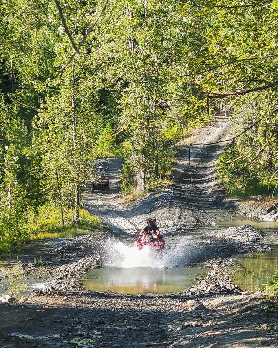 An ATV shoots through the water in Whistler, BC