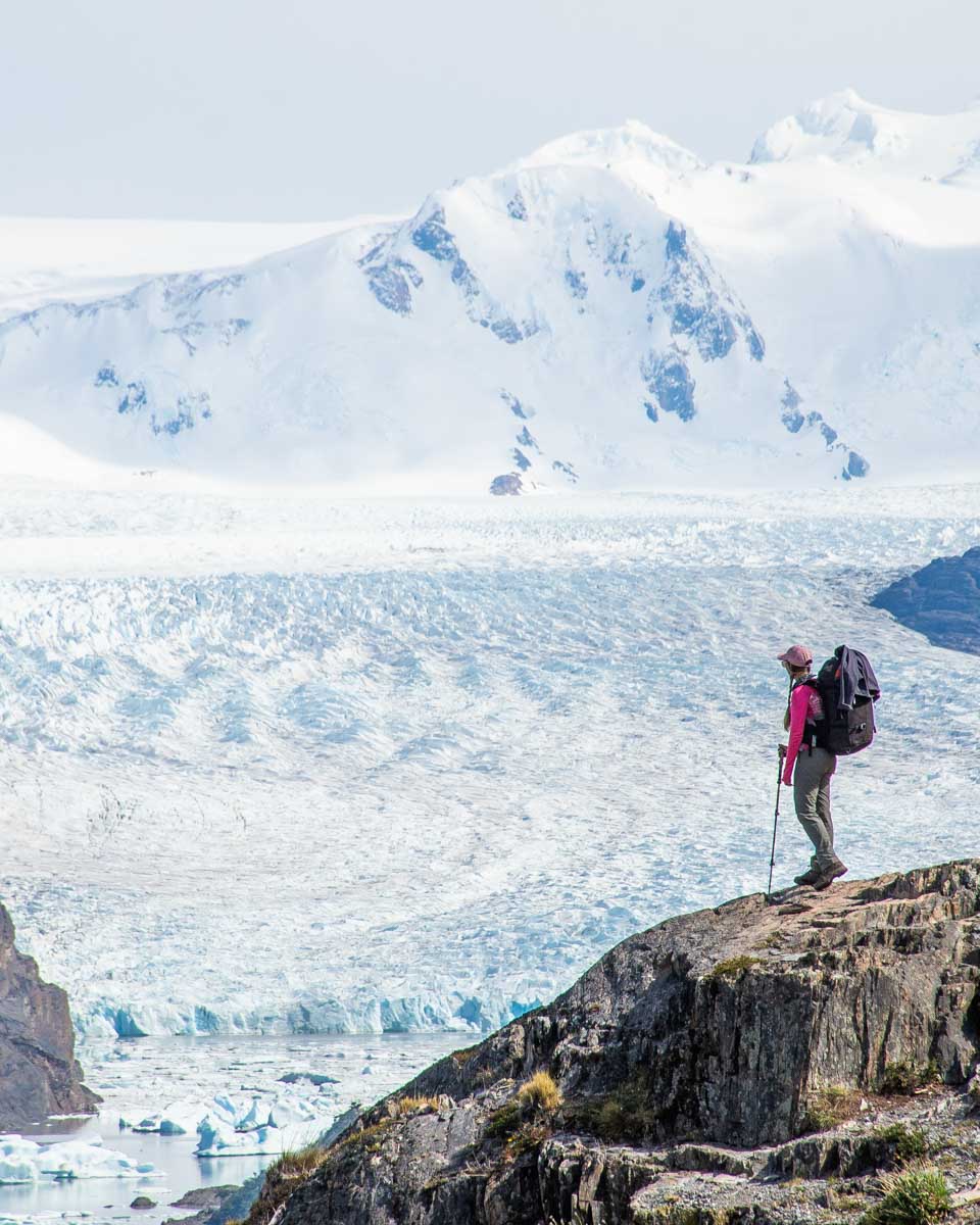 Bailey stands on a ledge with glacier Grey in the Background on the W Trek
