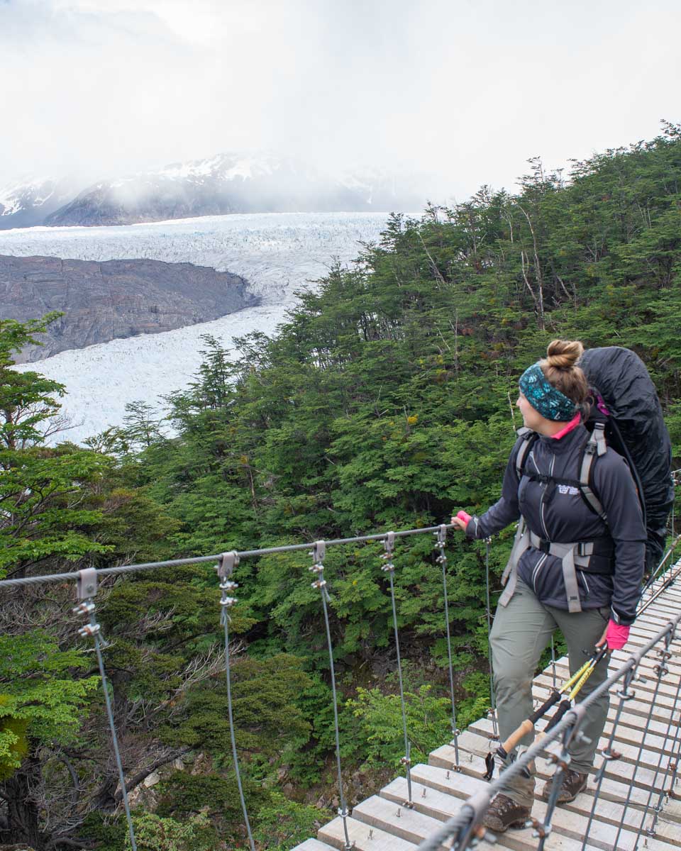 Bailey walks across a suspension briedge near Glacier Grey in Torres del Paine National Park