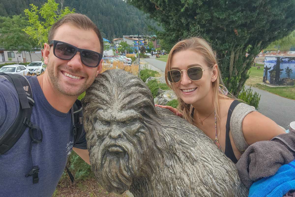 Daniel and Bailey take selfie with the Sasquatch statue in Harrison Hot Springs, Canada