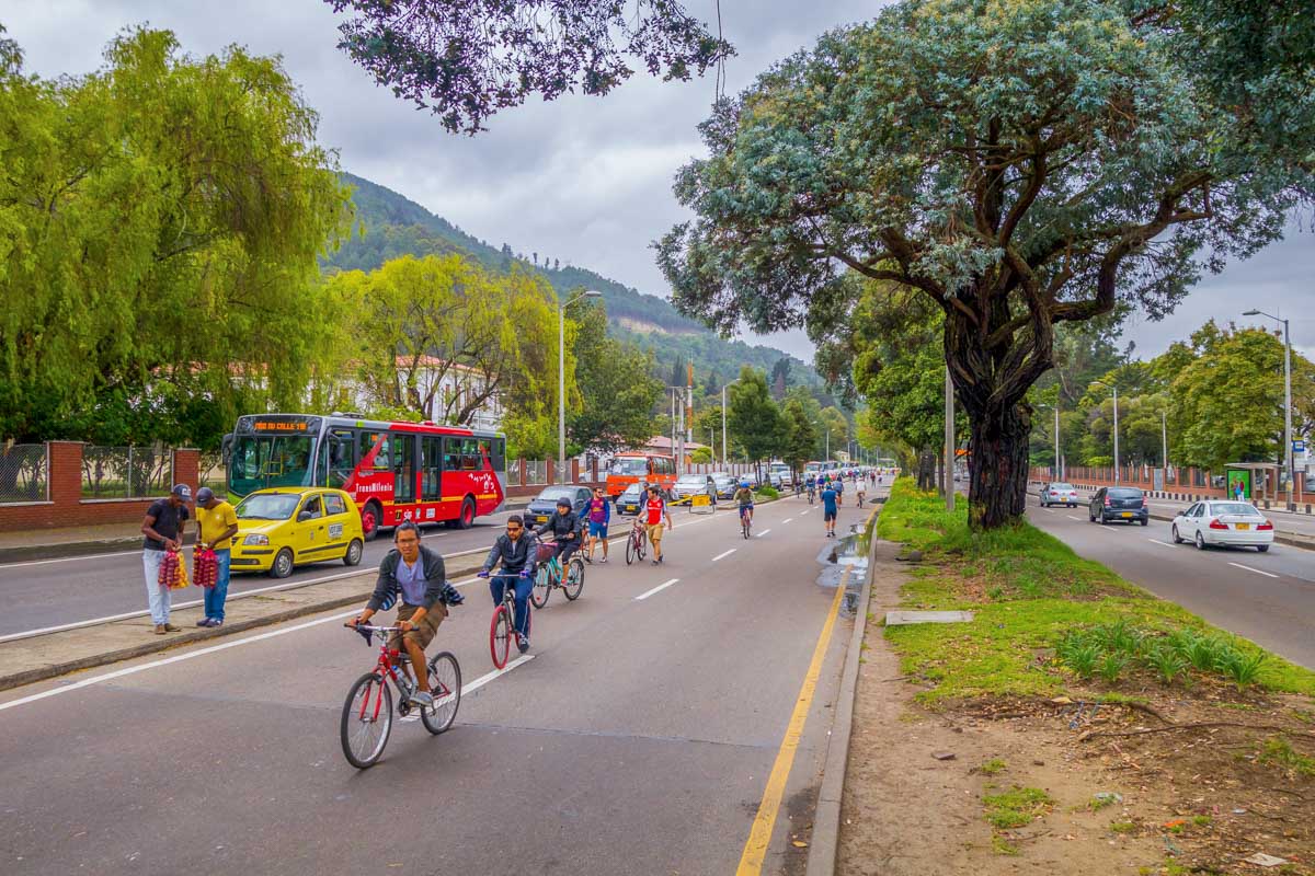 People ride bikes through a street in Bogota, Colombia