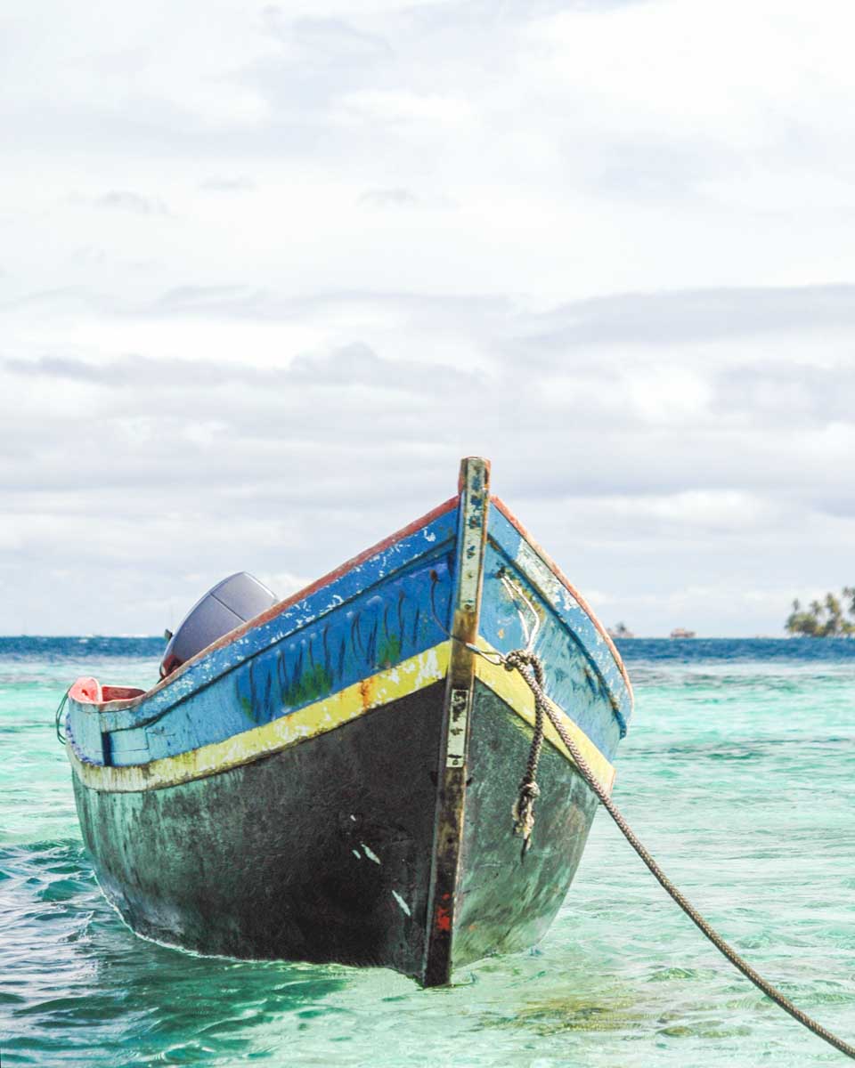 A small wooden fishing boat on a beach in the San Blas Islands, Panama