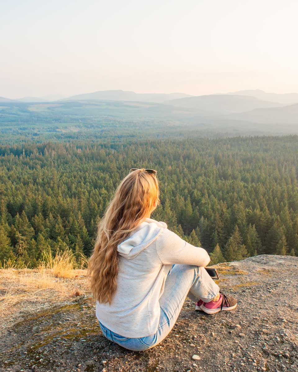 Bailey sits and enjoys the view from Little Mountain Lookout for Sunset in Parksville