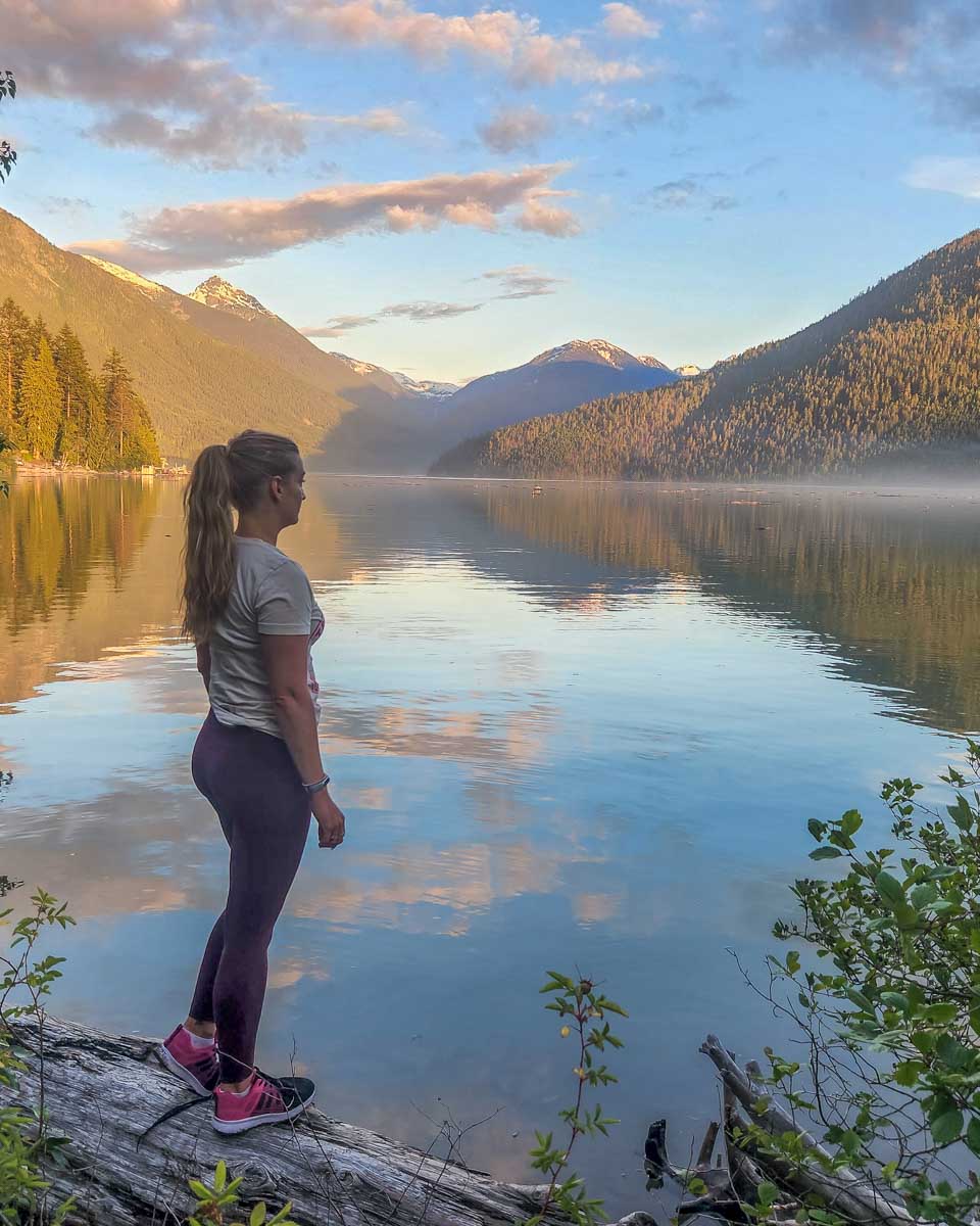 Bailey stands at Lillooet Lake at sunset in Pemberton, BC