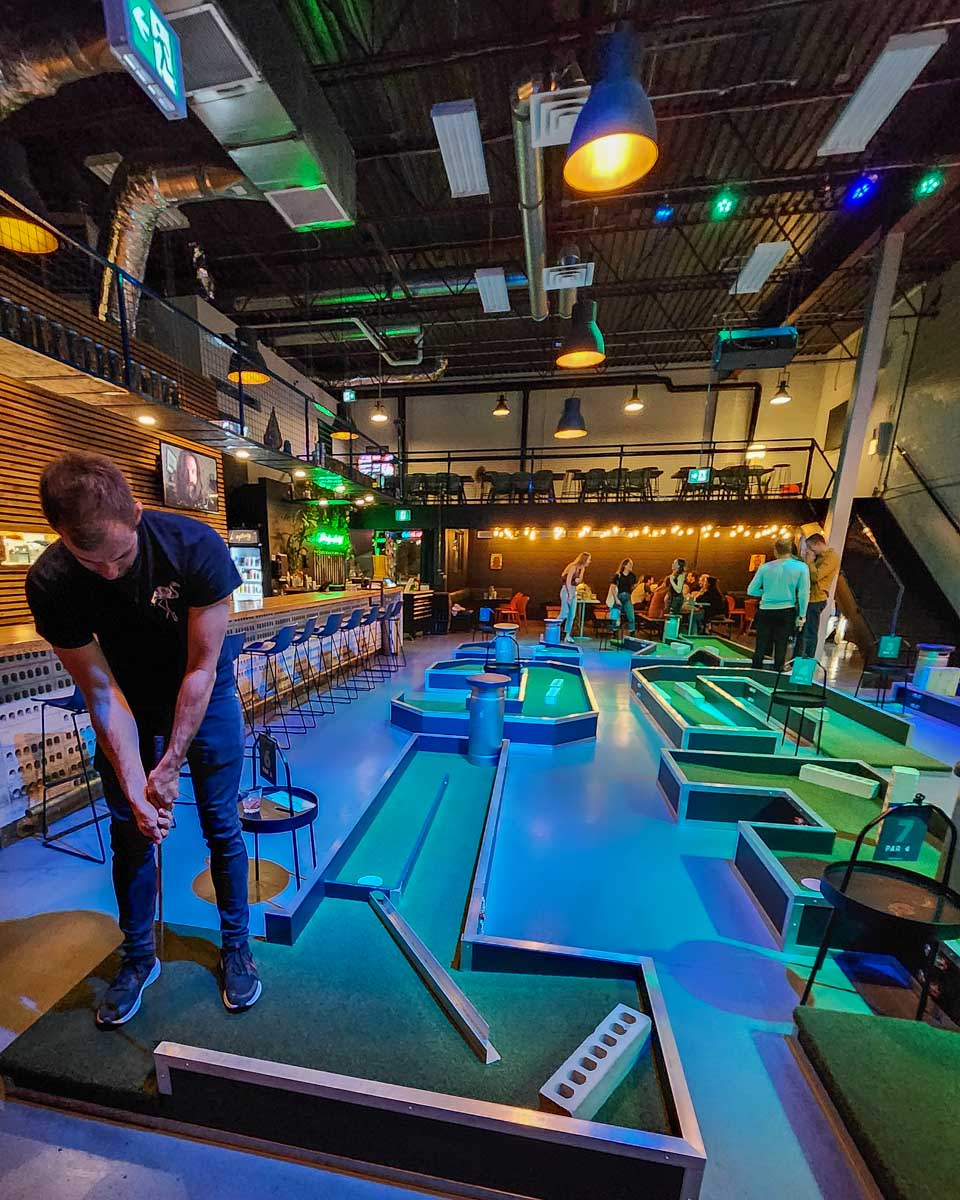 Daniel plays minigolf at Taiko Canteen in Calgary
