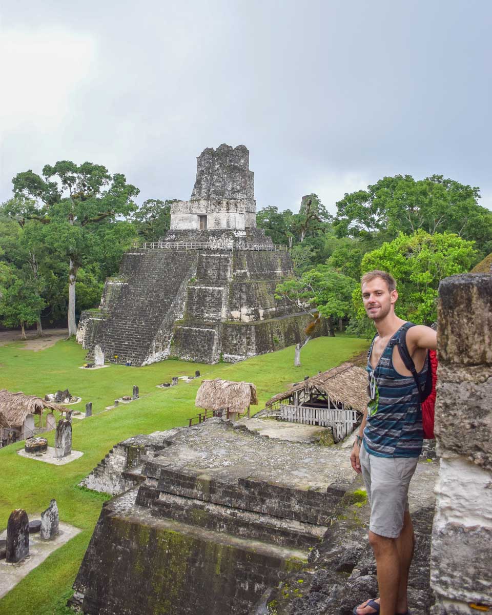 Daniel stands on a temple in Tikal and looks down at the restored ruins