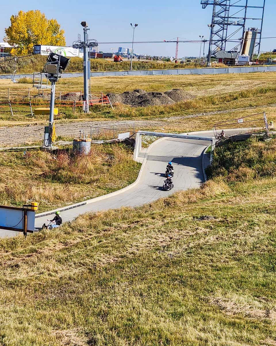 People ride down the Luge on the track in Calgary