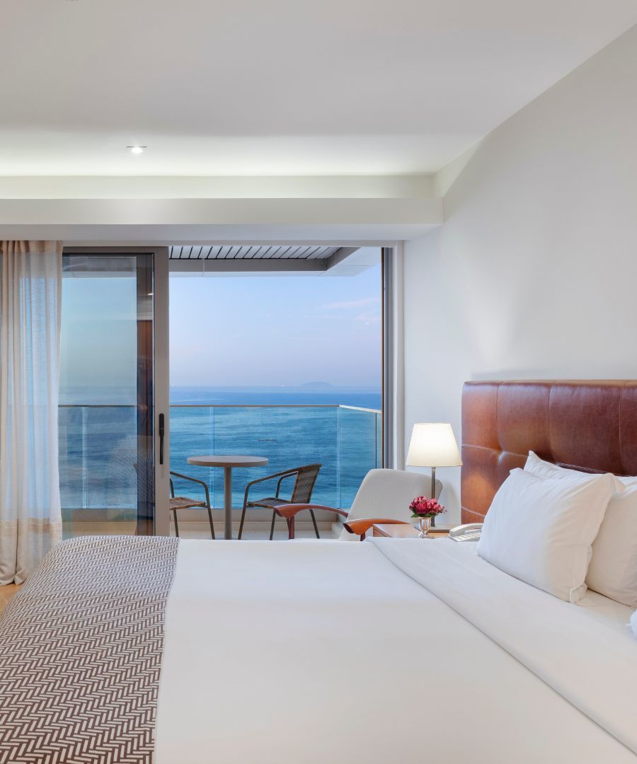 a clean hotel room with patio overlooking the ocean