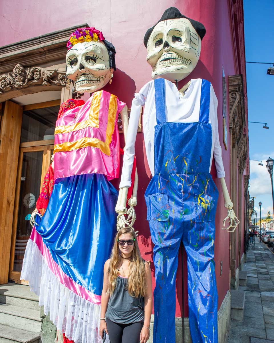 Bailey poses with two giant puppets during Día de los Muertos in Oaxaca