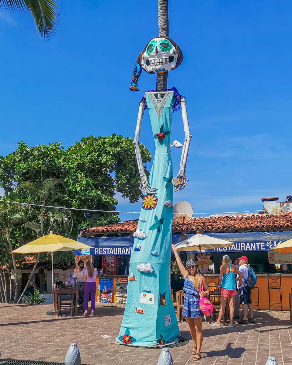 Bailey stands below a giant puppet during Día de los Muertos in Puerto Vallarta