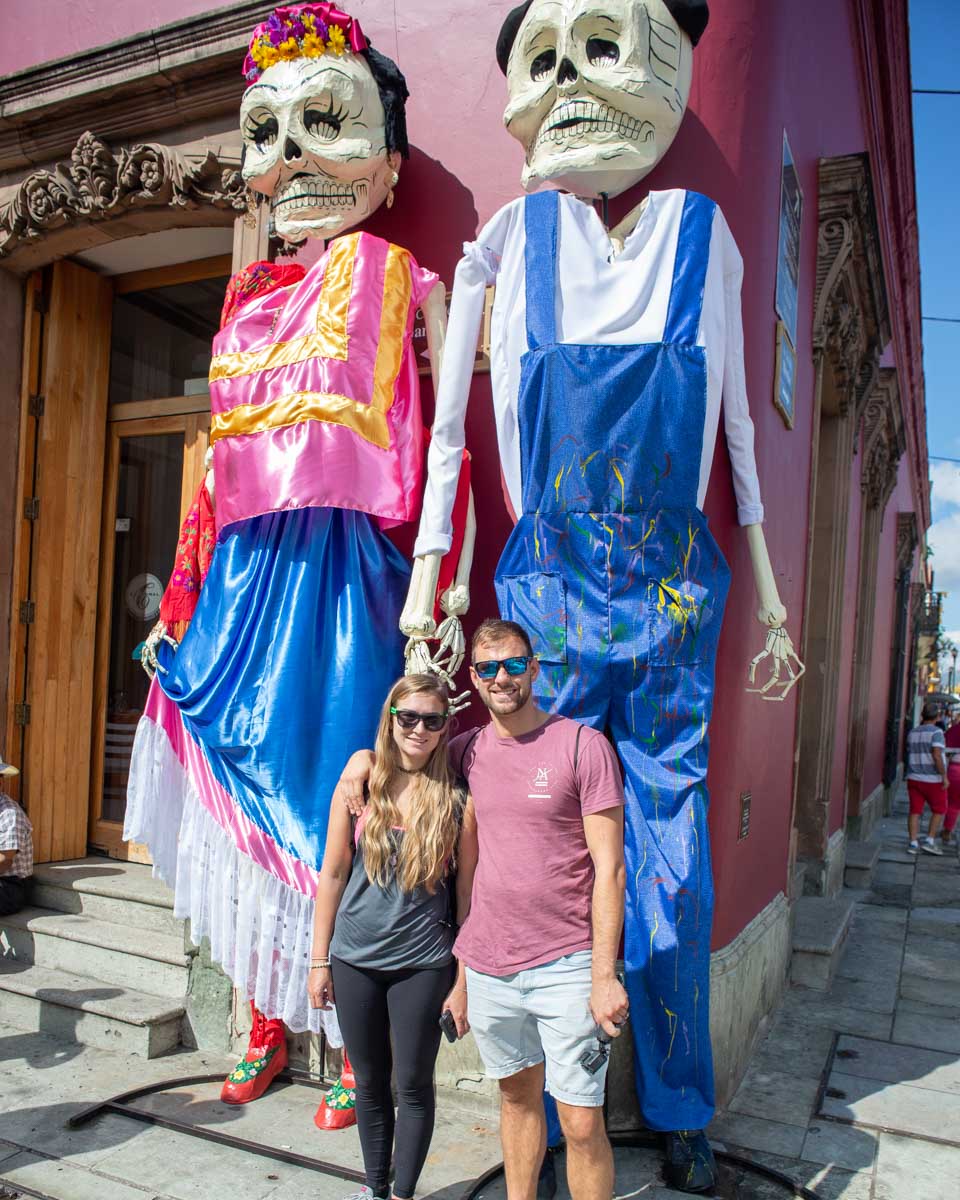 Daniel and Bailey with two huge puppets in the streets of Oaxaca during Día de los Muertos