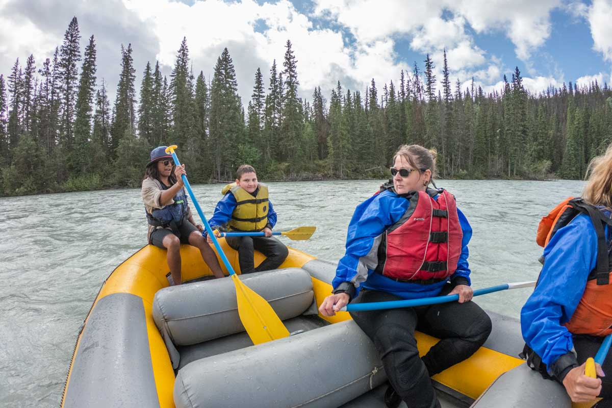 A group of white water rafters rest on a tour in Jasper before the next rapids