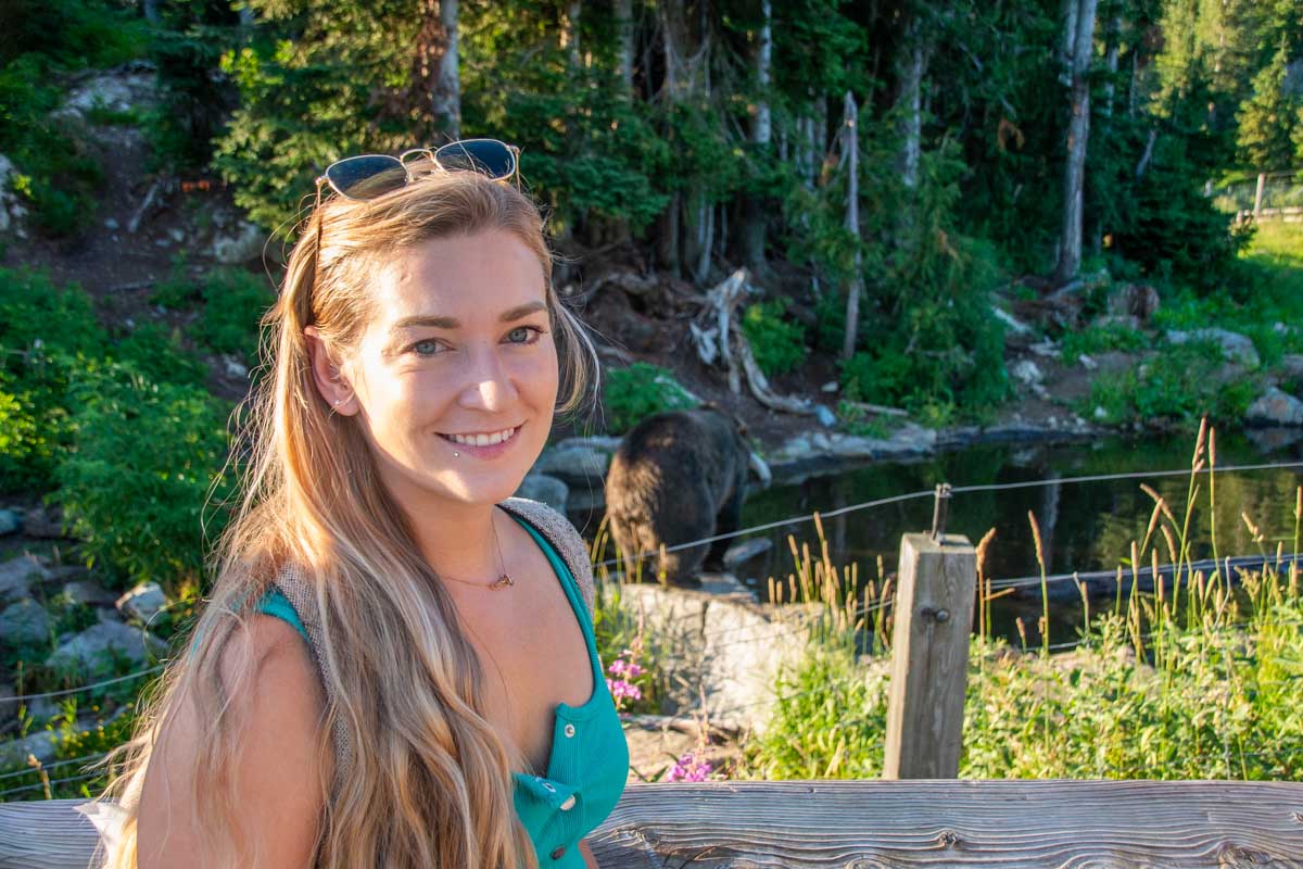 Bailey poses for a photo at the bear enclosure on Grouse Mountain, Vancouver with Grinder the bear