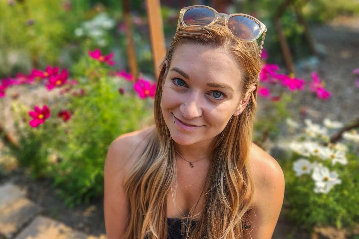 Bailey sits in the gardens at The Butchart Gardens with flowers around her