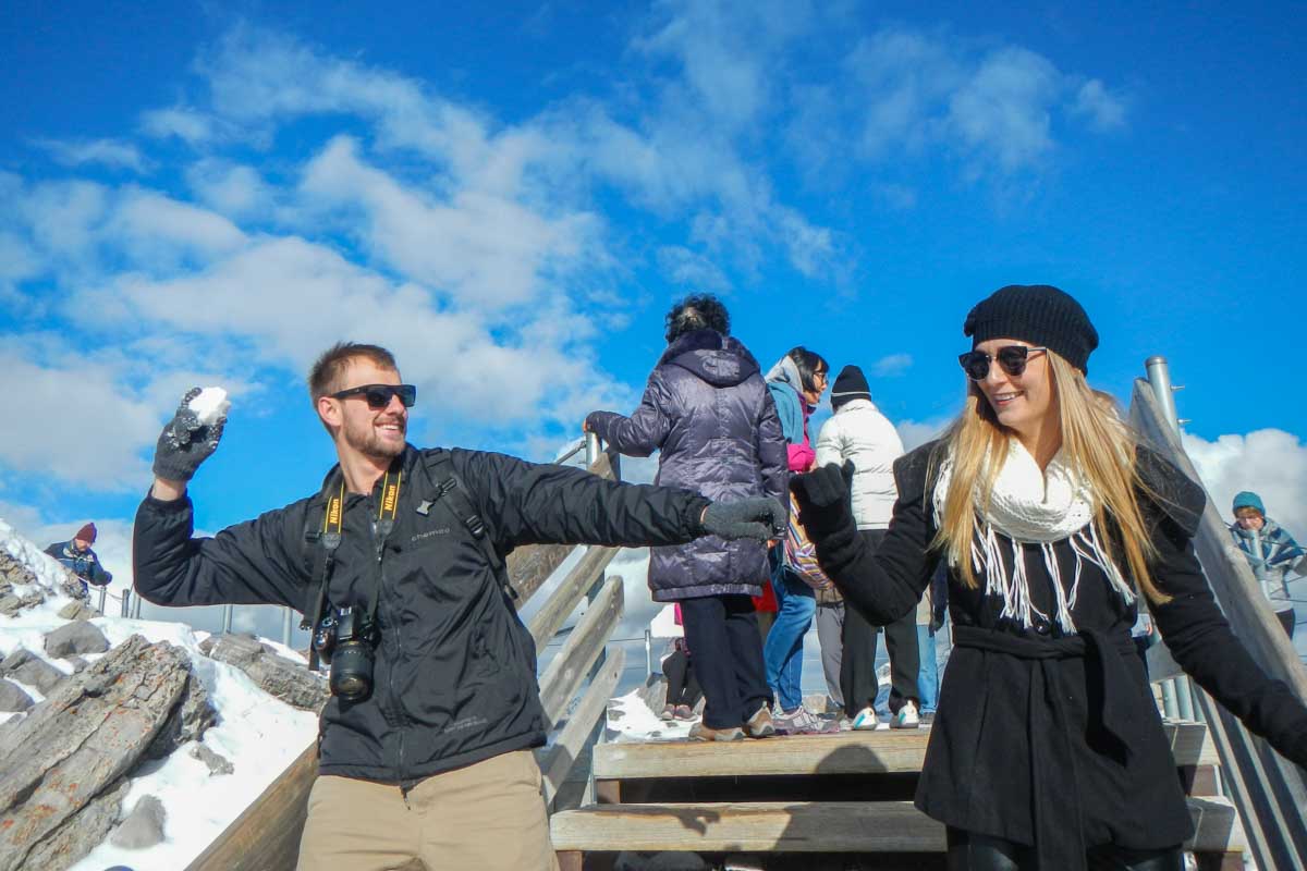 Daniel pretends to throw and snow ball at Bailey at the top of the Banff Gondola on Sulphur Mountain
