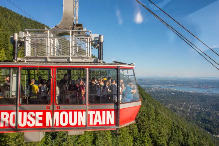 Skyride gondola heads down Grouse Mountain, Vancouver with views of the city