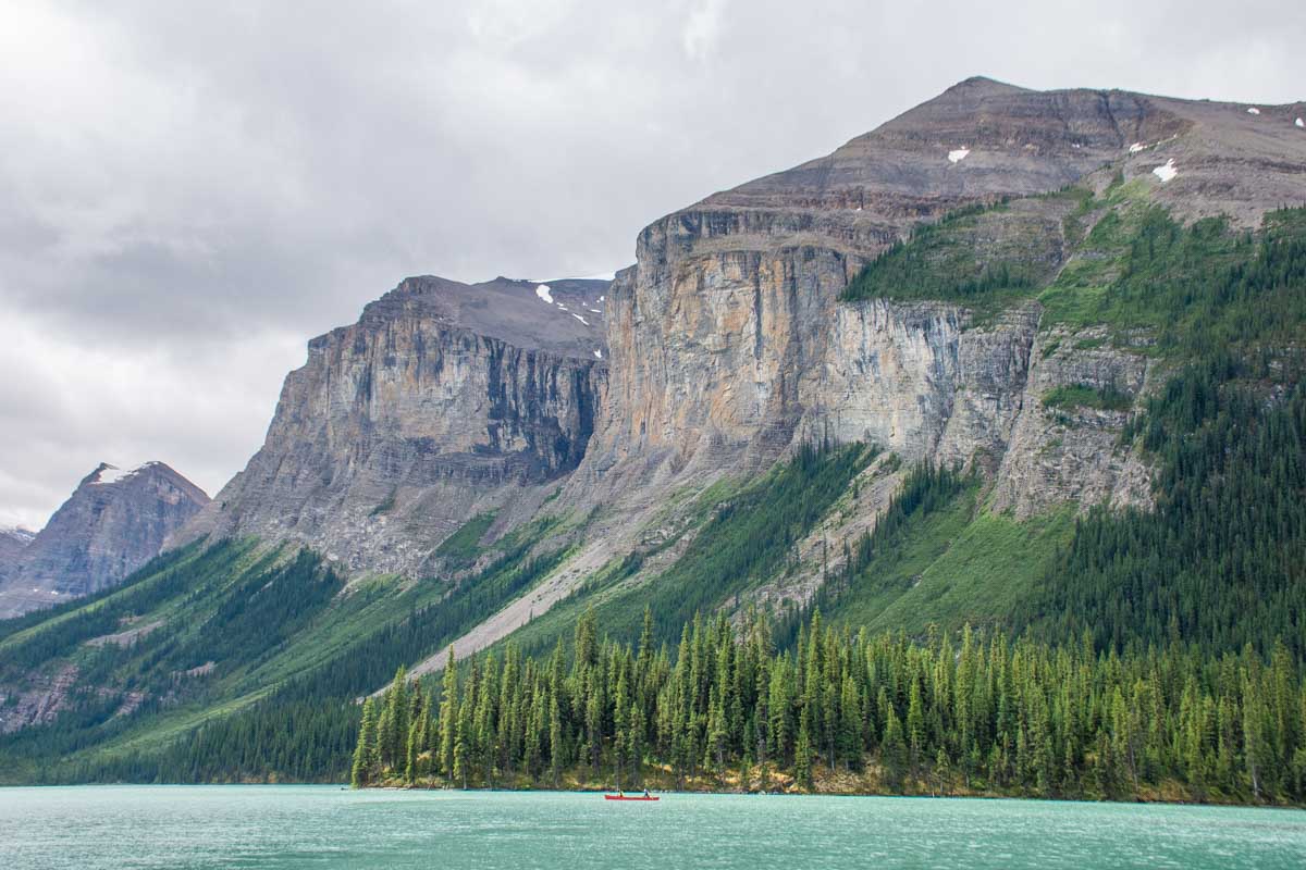 Tall mountain and a canoe on Maligne Lake near Spirit Island
