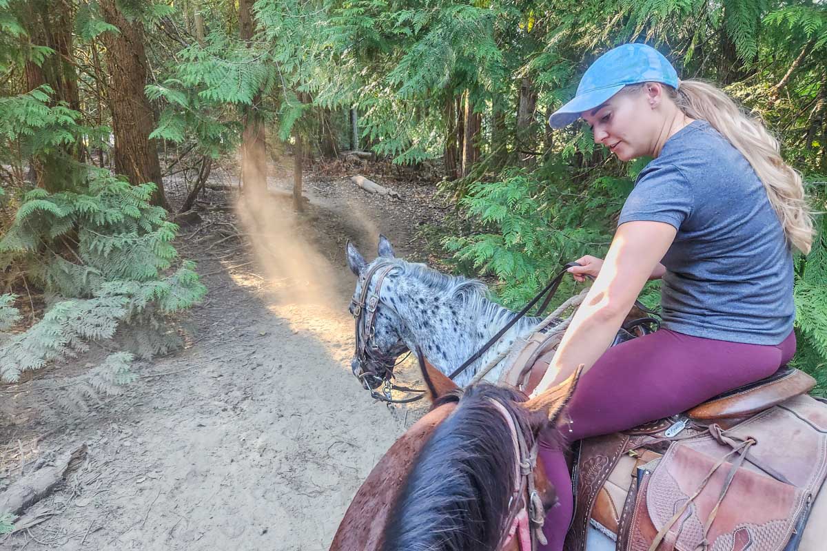 Bailey pats my horse on a horseback riding tour in Pemberton BC