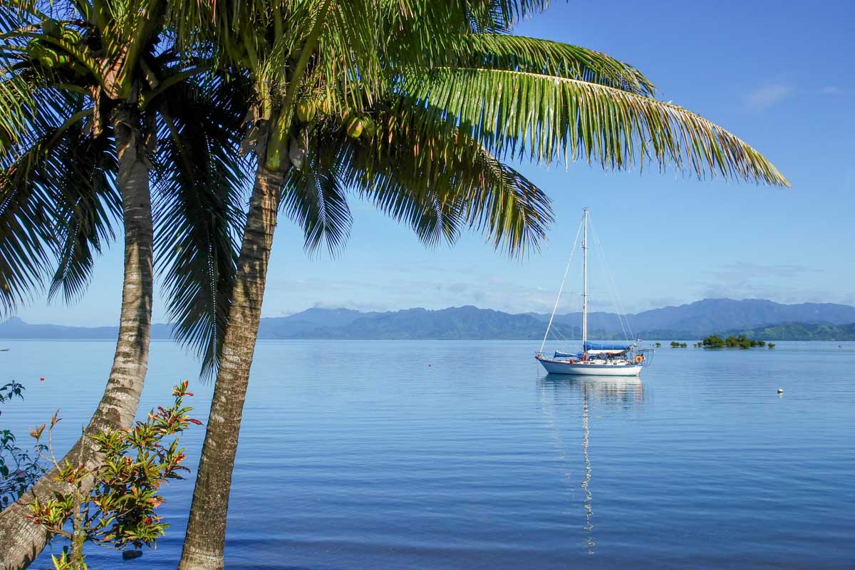 A boat is anchored off a beach in Fiji