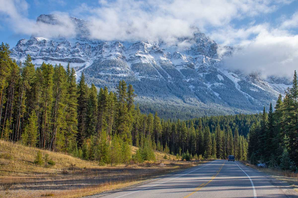 A car drives along the Bow Valley Parkway in Banff National Park