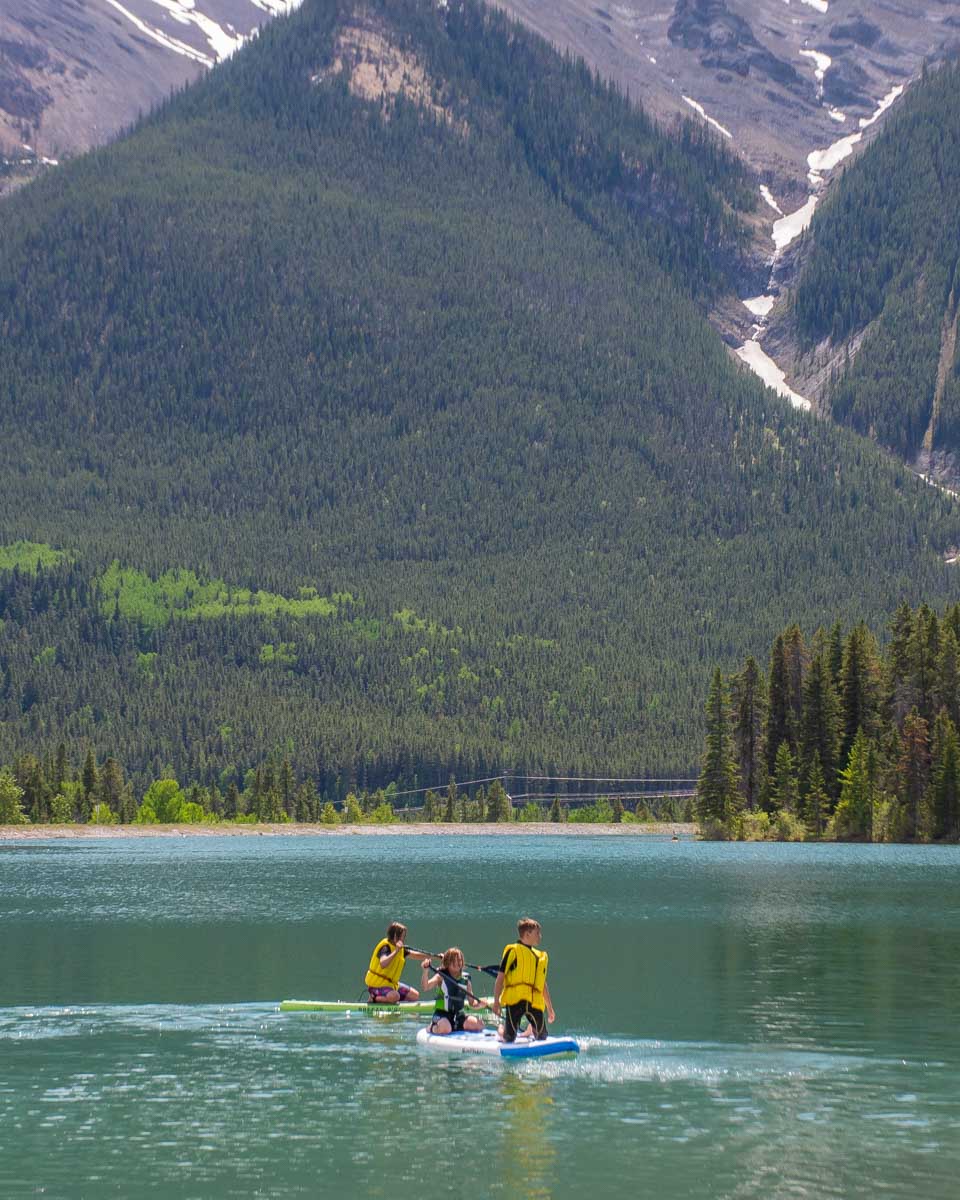A group of people SUP in Canmore reservoir