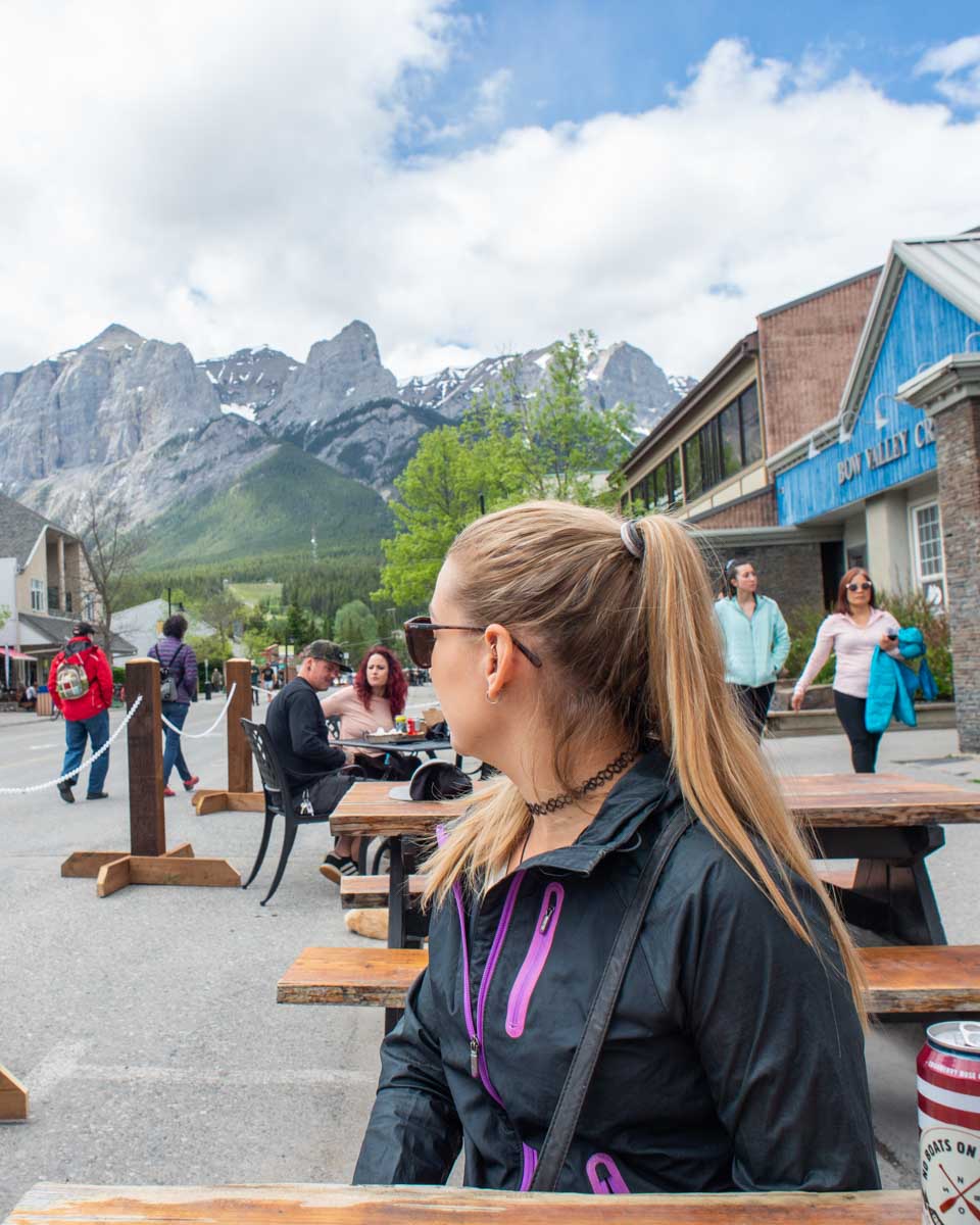 bailey sitting at a picnic table with a beer can on Main Street in Canmore