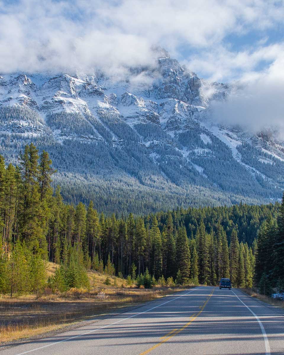 A car drives along the Bow Valley Parkway