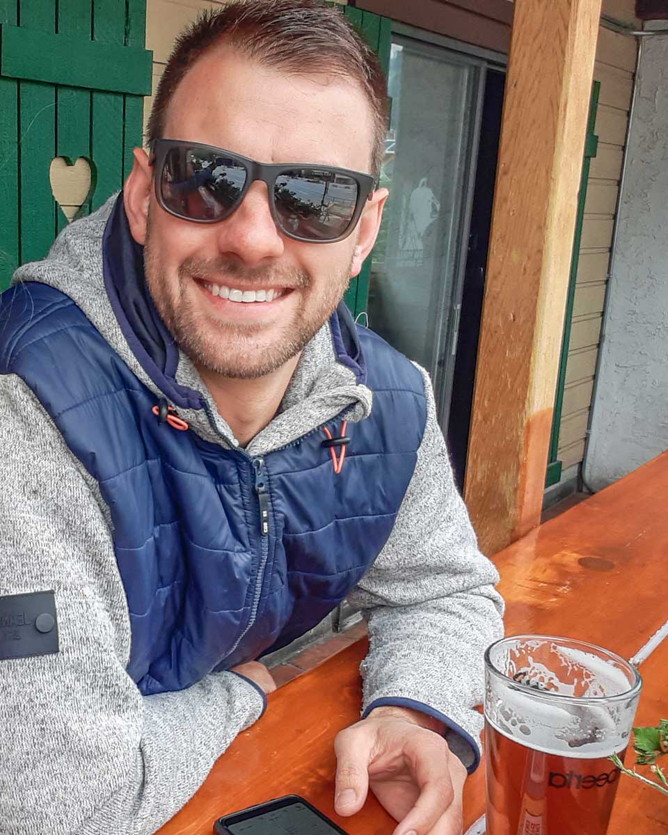 Daniel sits on a sunny winter day in Canmore drinking a beer
