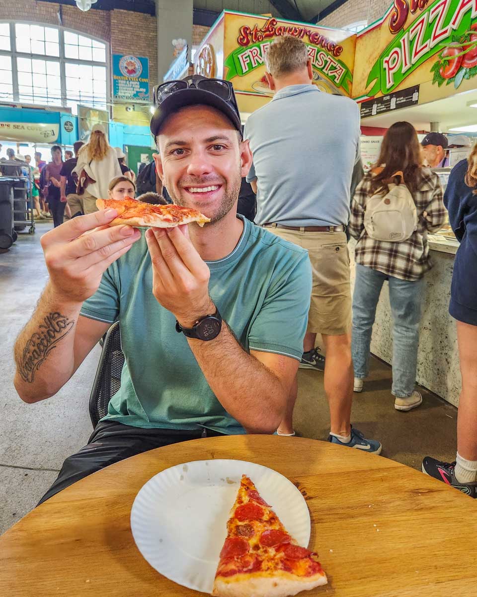 Daniel enjoys a slice at St Lawrence Pizza and Pasta in the St Lawrence Market, Toronto